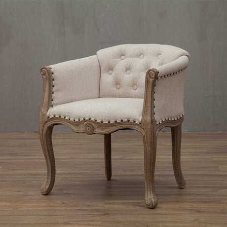 Willem Accent Chair: Beige upholstered accent chair with tufted back, distressed wood frame, and nailhead trim.