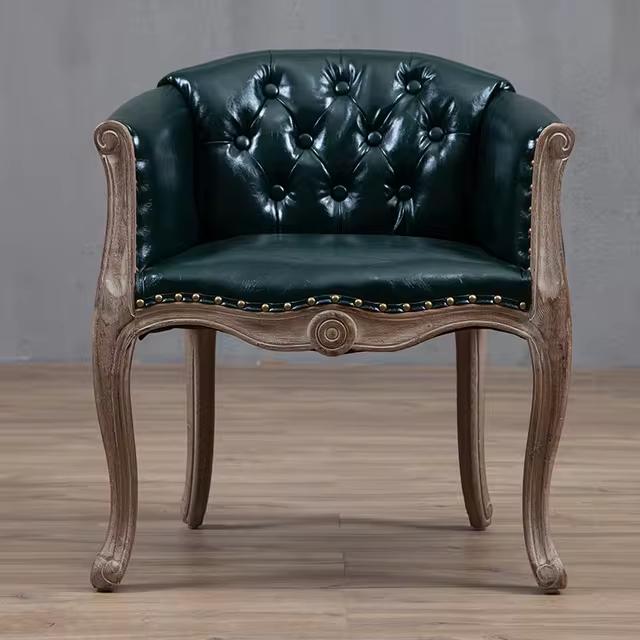 Willem Accent Chair in emerald leather with tufted back, brass nailheads, and carved light wood frame.