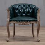 Willem Accent Chair in emerald leather with tufted back, brass nailheads, and carved light wood frame.