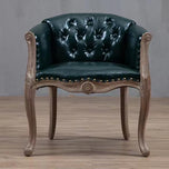 Willem Accent Chair in emerald leather with tufted back, brass nailheads, and carved light wood frame.