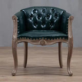 Willem Accent Chair in emerald leather with tufted back, brass nailheads, and carved light wood frame.