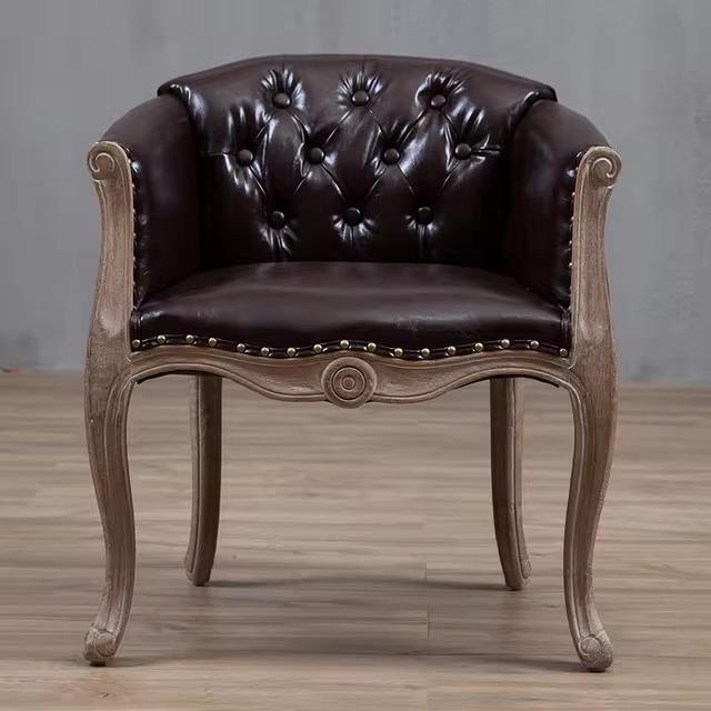 Willem Accent Chair in classic brown leather with tufted back, brass studs, and distressed light wood frame.