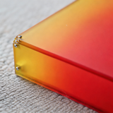 Horizon Wall Light, a rectangular acrylic wall sconce with a red to yellow gradient, on a textured surface.