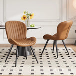 Lorca dining chair in brown faux leather with vertical channel tufting and black tapered legs.