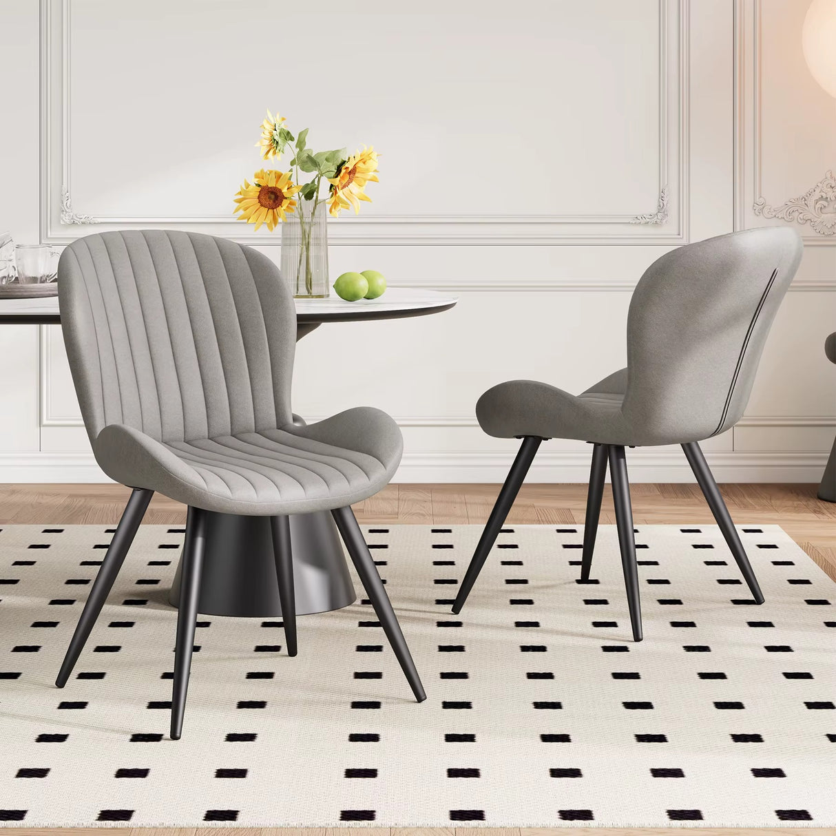 Lorca Dining Chair in light gray fabric with vertical channel tufting and black tapered legs, on a rug.