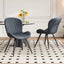 Lorca dining chair in dark gray fabric with vertical channel tufting and black tapered legs.