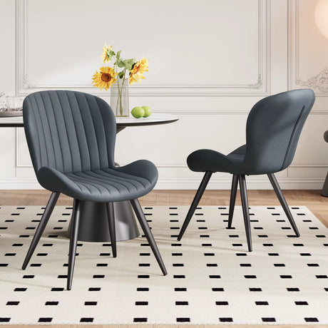 Lorca dining chair in dark gray fabric with vertical channel tufting and black tapered legs.