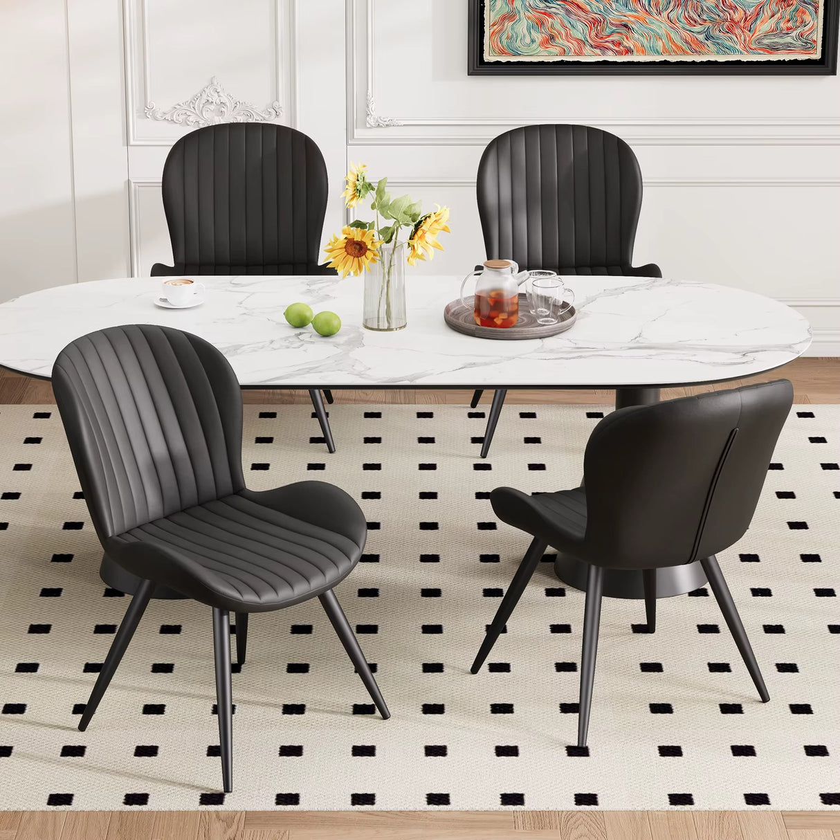Lorca dining chair in black faux leather with vertical channel tufting and black metal legs, shown with a white marble table.