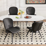 Lorca dining chair in black faux leather with vertical channel tufting and black metal legs, shown with a white marble table.