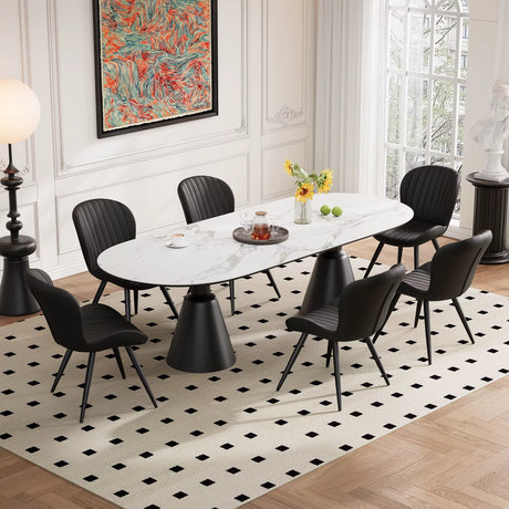 Lorca Dining Chair, black faux leather with vertical stitching, shown around a white marble oval table.