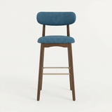 Norden Bar Stool with blue upholstered seat and back, dark wood frame, and brass footrest.