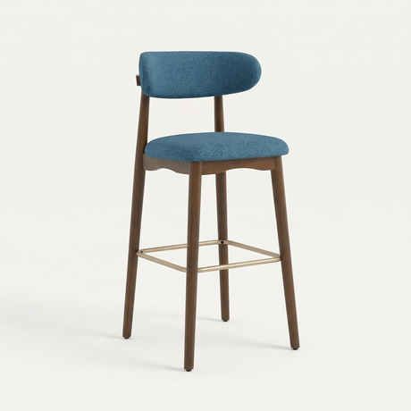 Norden Bar Stool in denim blue fabric with a dark wood frame and brass footrest.