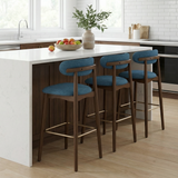 Norden Bar Stool. Three mid-century modern bar stools with teal fabric seats and walnut wood frames in a kitchen.