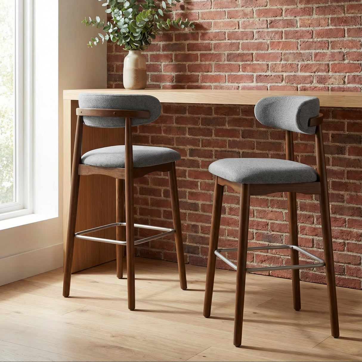 Norden Bar Stool: Two mid-century modern bar stools with gray upholstered seats and dark wood frames.