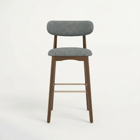 Norden Bar Stool with gray upholstered seat and back, dark wood frame, and brass footrest.