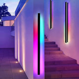 Parc Sconce outdoor wall light, 30cm black linear RGB LED sconce illuminating a modern exterior wall and stairs.