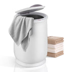White Parc Towel Warming Bucket with an open lid, a gray towel draped over the edge, and a stack of folded towels.