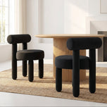 Rogolo dining chair, black velvet, with a rounded backrest and thick, cylindrical legs.