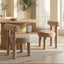 Rogolo dining chair in sand fabric, with a round seat and backrest, and thick cylindrical legs.